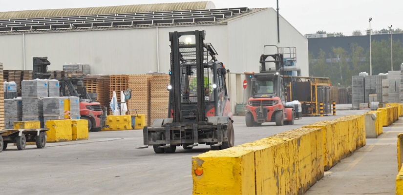 a forklift with a trailer and stacks of crates